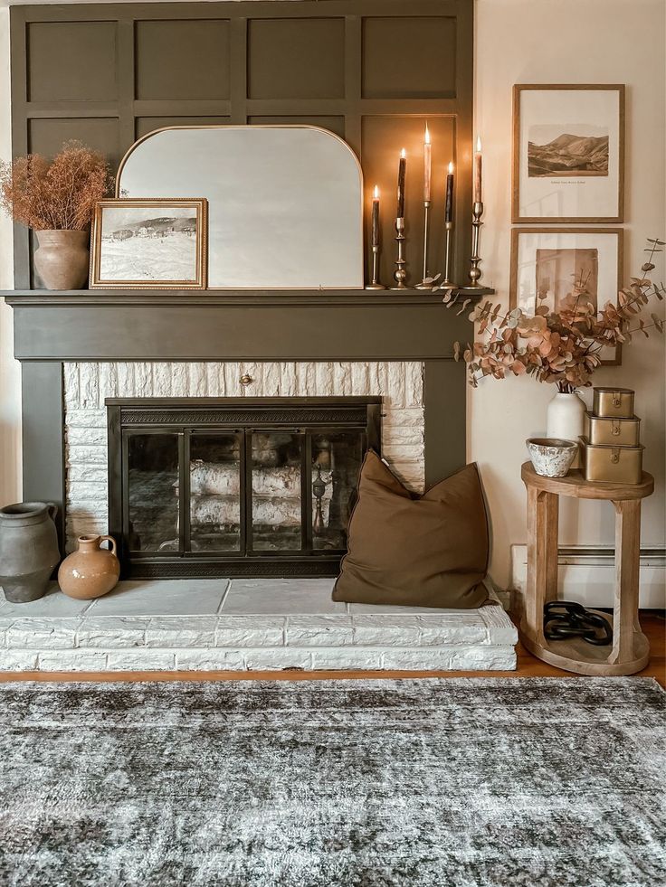 a living room filled with furniture and a fire place covered in candles on top of a mantle