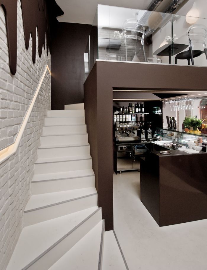 the interior of a restaurant with stairs leading up to an upper level kitchen and dining area