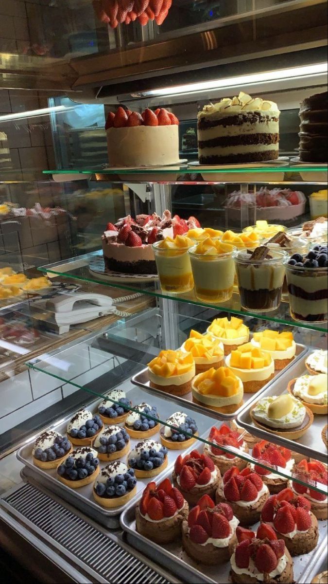 a display case filled with lots of cakes and desserts