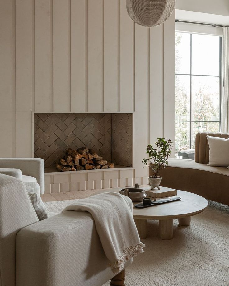 a living room filled with furniture and a fire place next to a window on top of a rug