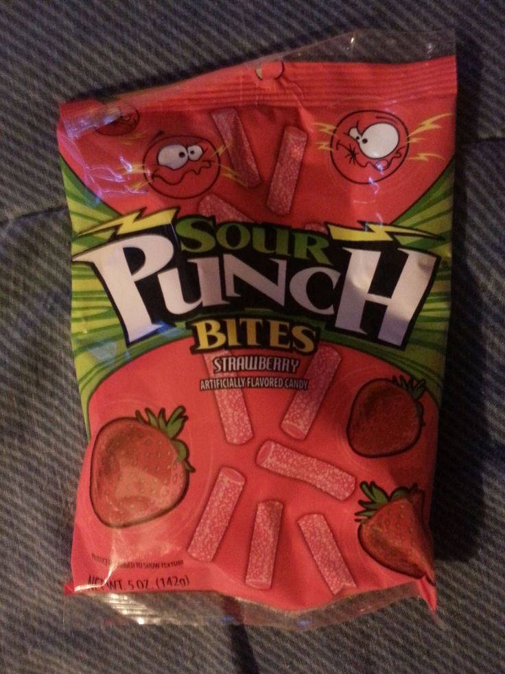 a bag of sour punch bites sitting on top of a bed