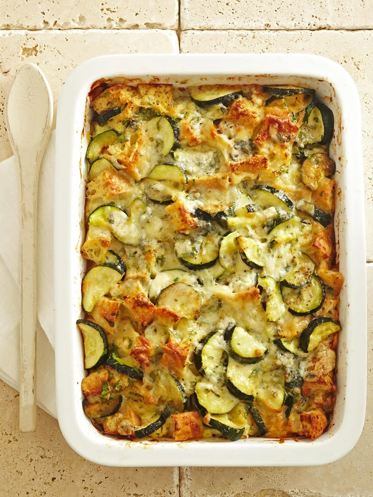 a casserole dish with zucchini and cheese in it on a table