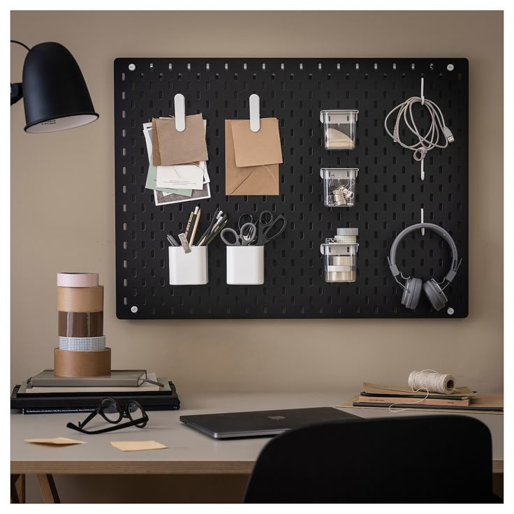 a black pegboard mounted to the side of a wall with office supplies on it