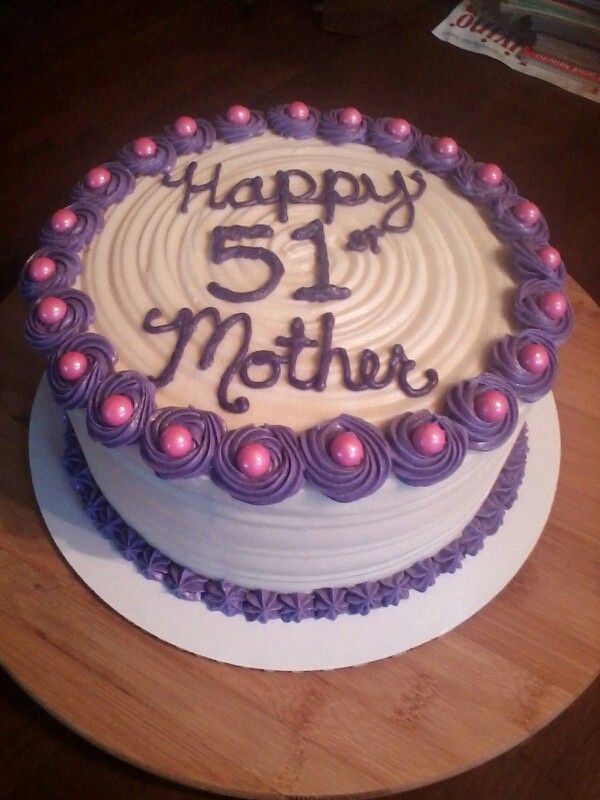 a birthday cake with purple icing and pink decorations on a wooden platter that says happy 5th mother