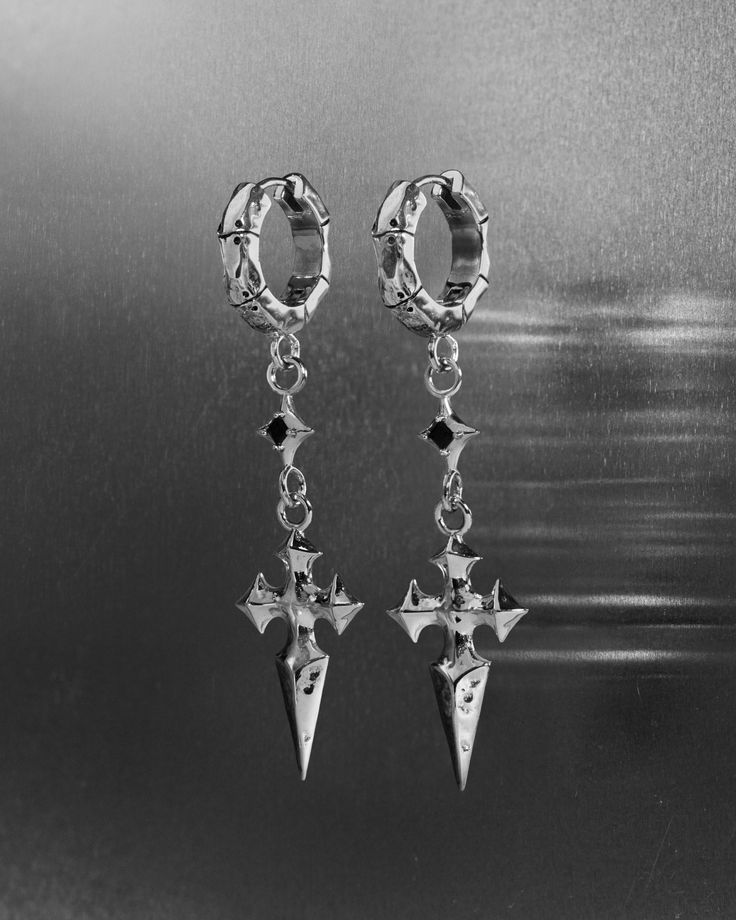 Fused from the essence of cosmic and eldritch energy, our MERCIA Earrings pierce the perimeters of magick; a demi-fine conduit for both alchemical and astrological forces.

Our COBALT earrings dangling a pointed gothic cross dagger—the symbol in our Ask & Embla engravable wordmark—with a black, star-silhouetted gem hanging from the cross’ lowest point. Forged entirely from 925 sterling silver for all genders and expressions. 

Sold as a pair. Each piece is lovingly crafted by hand, under ethical Gothic Cross, Gothic Crosses, Earrings Dangling, Alternative Jewelry, Earrings Ear, Studs Earrings, True Self, Online Jewelry Store, Black Star