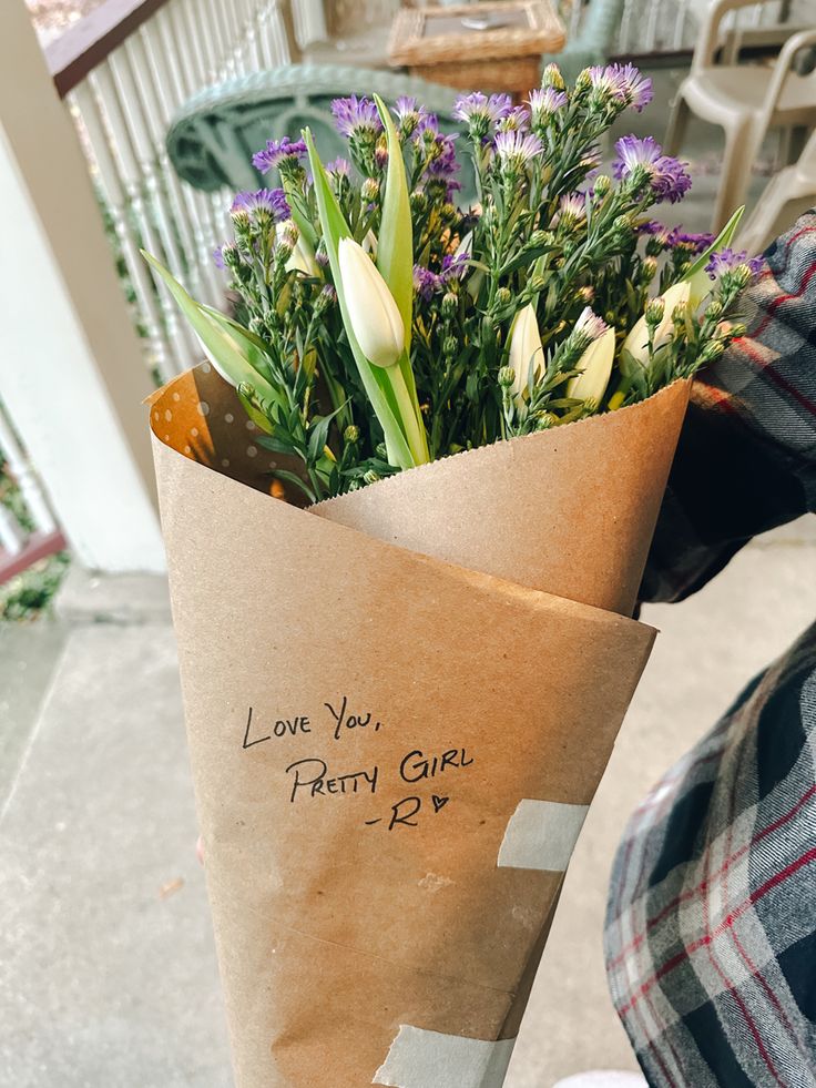 a bouquet of flowers wrapped in brown paper