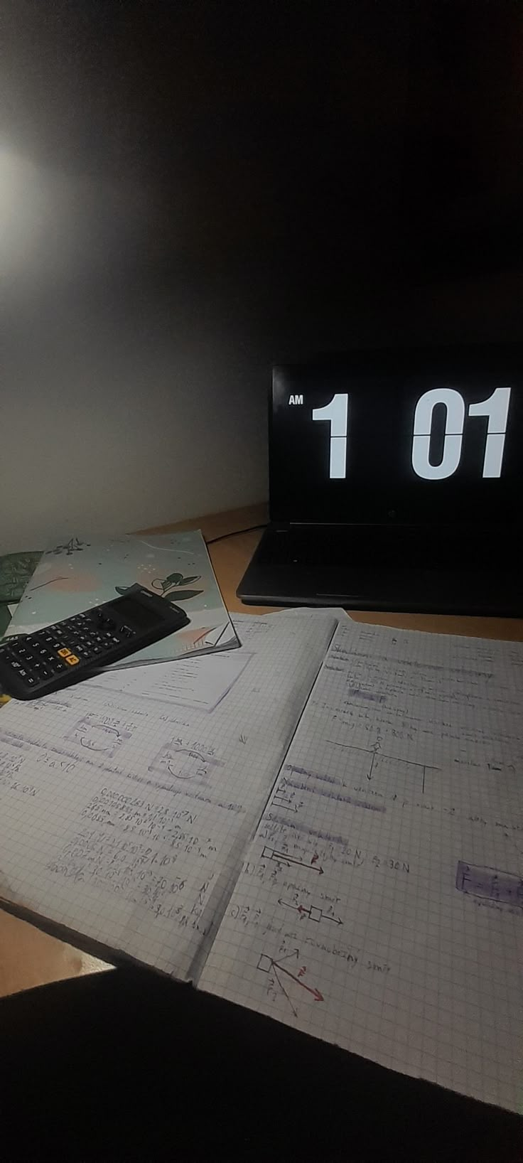 an open notebook sitting on top of a wooden desk next to a computer mouse and calculator