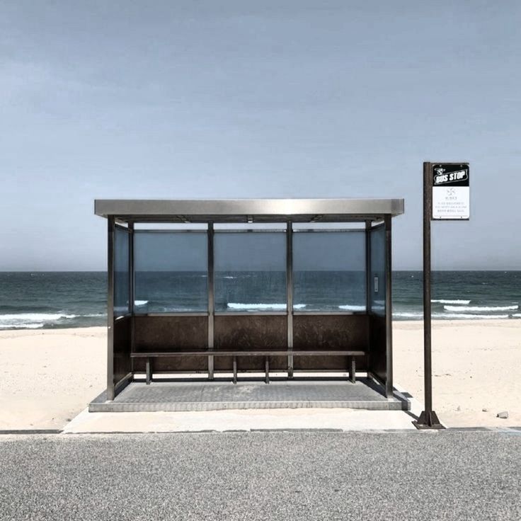 a bus stop sitting on top of a sandy beach