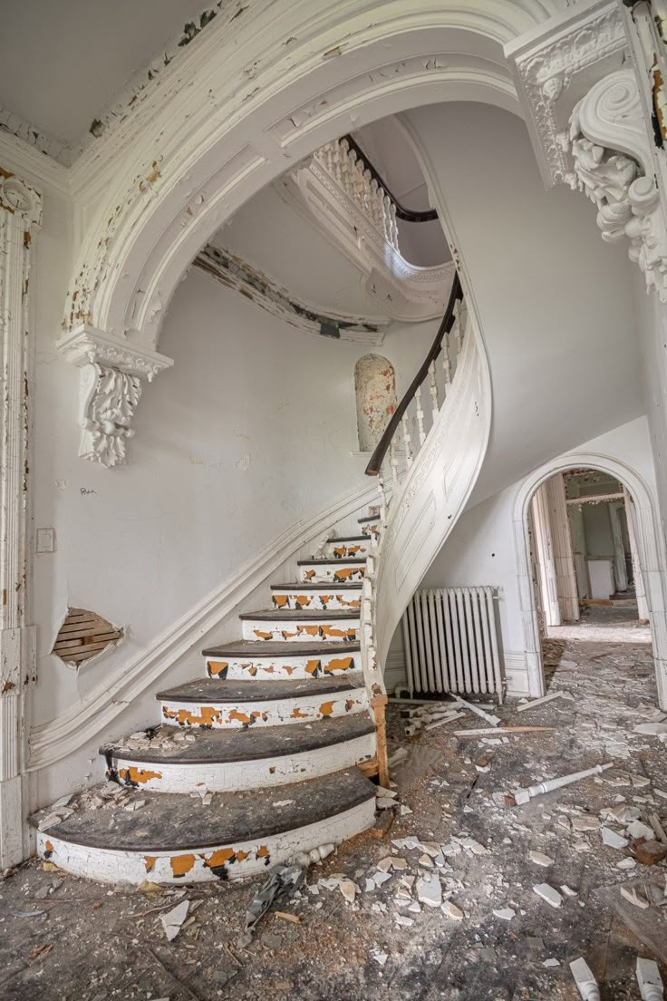 an old run down building with stairs leading up to the second floor and another room in the background