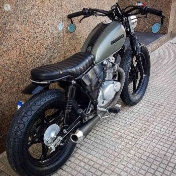 a motorcycle parked next to a building on the sidewalk