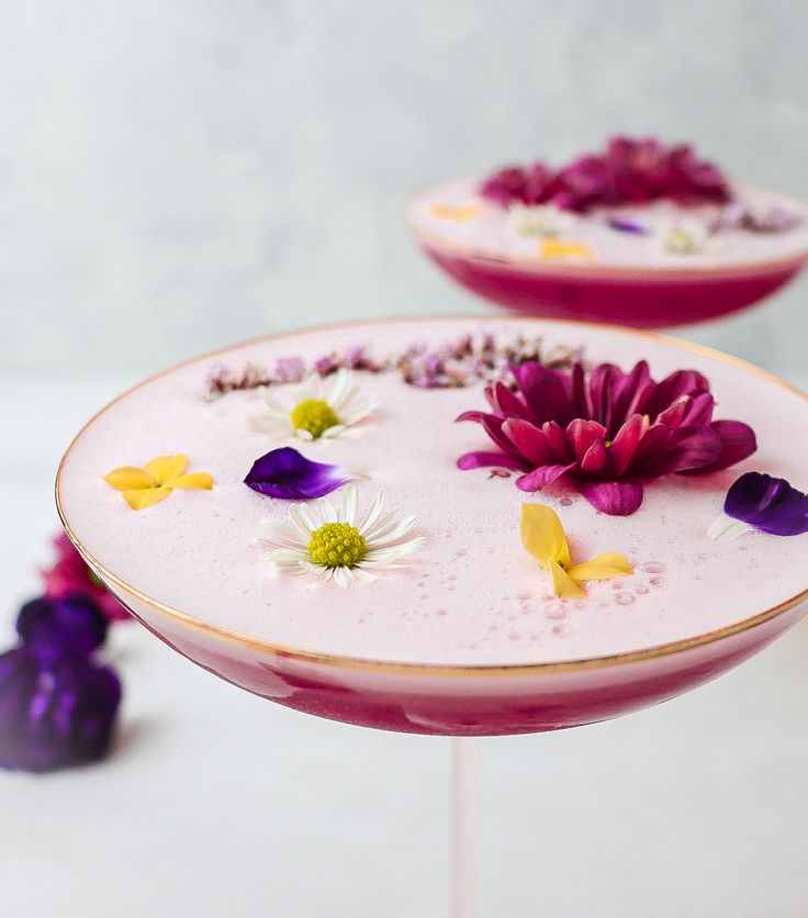 two pink plates with flowers on them sitting on a white counter top next to each other