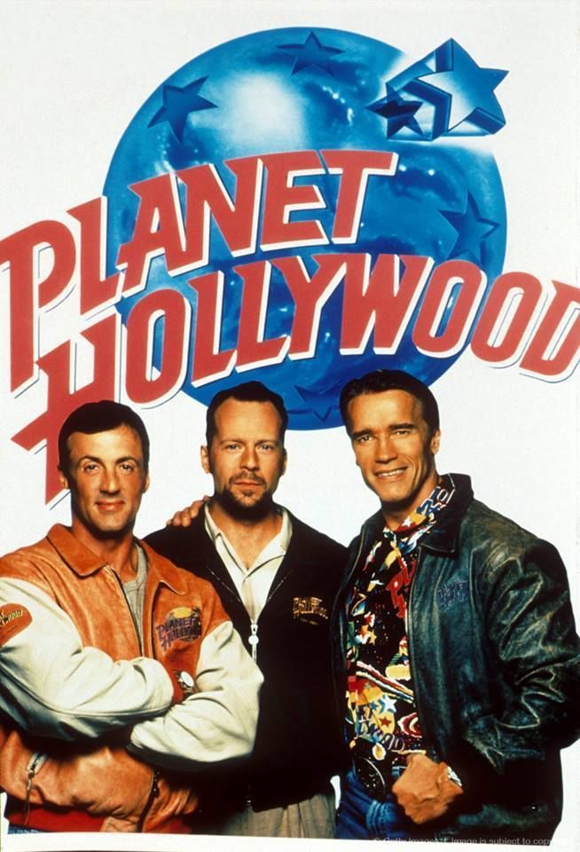 three men standing in front of a planet hollywood sign with the words planet hollywood on it