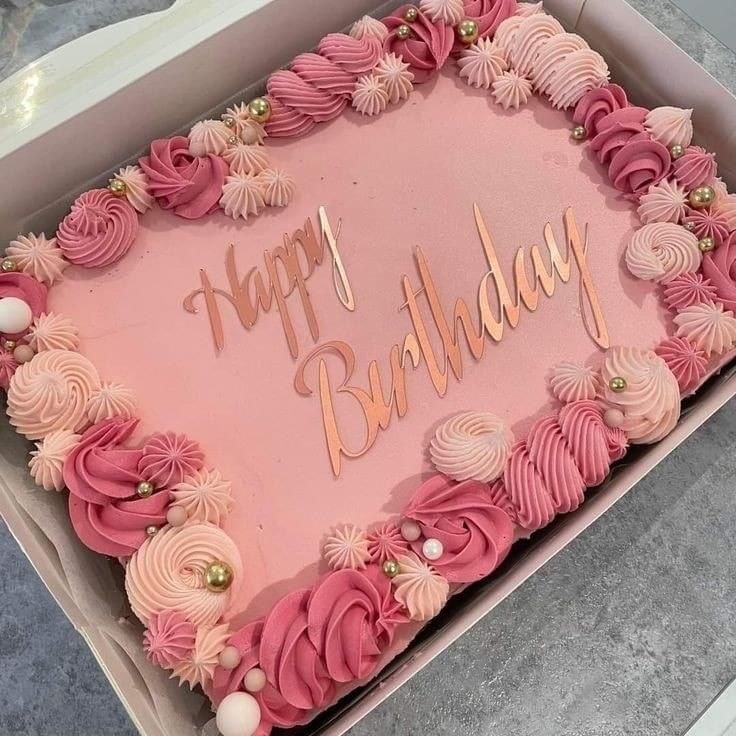 a pink birthday cake in a box with the words happy birthday written on it's side