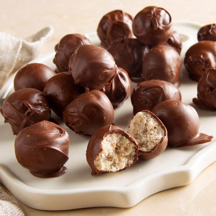 there are chocolates that have been cut in half on a white platter with a bite taken out