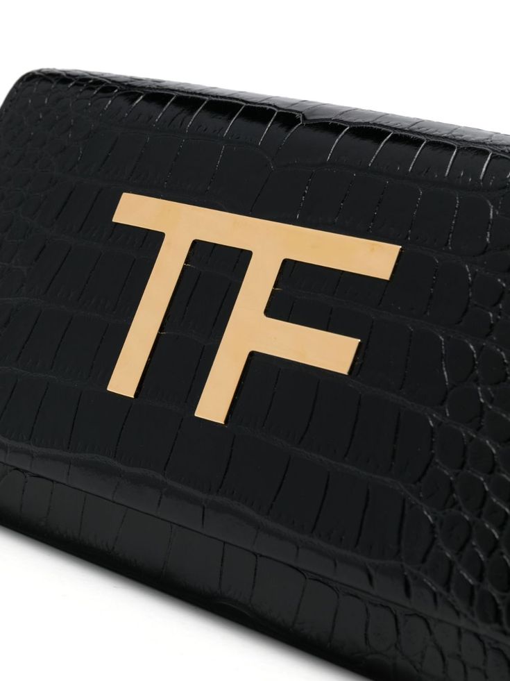 logo-plaque leather cluch bag from TOM FORD featuring black, calf leather, embossed crocodile effect, gold-tone logo plaque, foldover top with press-stud fastening, chain-link shoulder strap, multiple internal slip pockets and partitioned compartment. Size Info UNI Color Detail Black Made In Italy Material Calf leather 100% Season One Fall-Winter Season Two Fall-Winter Product bags.. Brand Tom Ford Size And Fit Width 8,27 in / 21 cm Height 5,51 in / 14 cm Depth 2,56 in / 6,5 cm Strap 44,09 in /