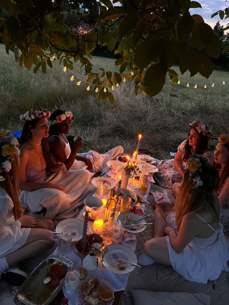 a group of women sitting around a table with food