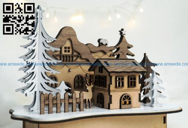 a wooden cutout of a house in the snow with trees and lights behind it