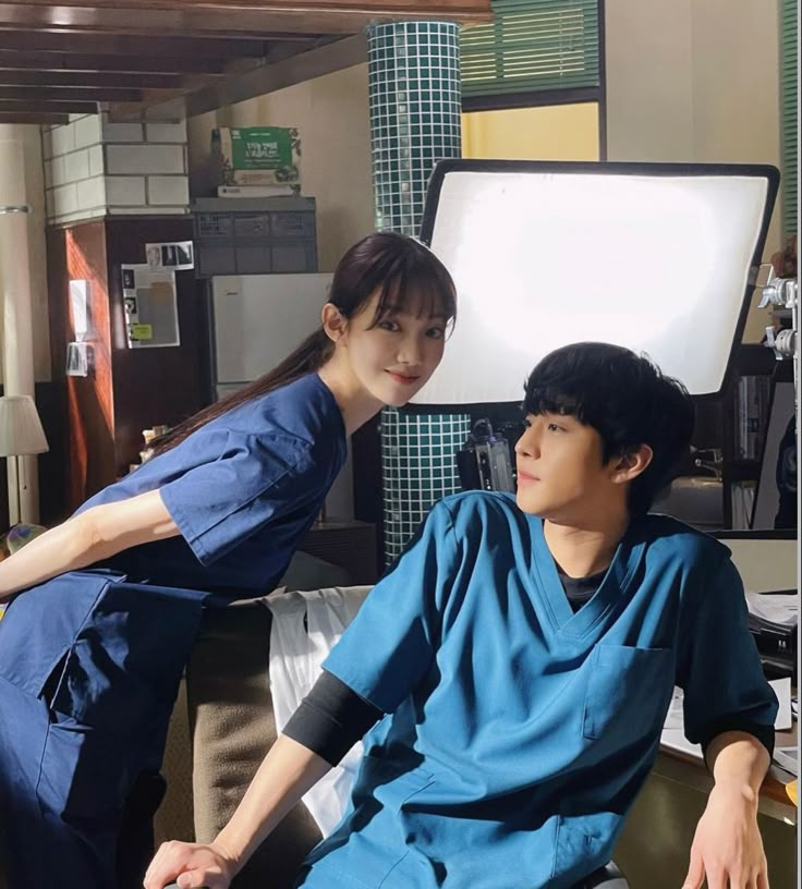 a man and woman in scrubs sitting on a couch