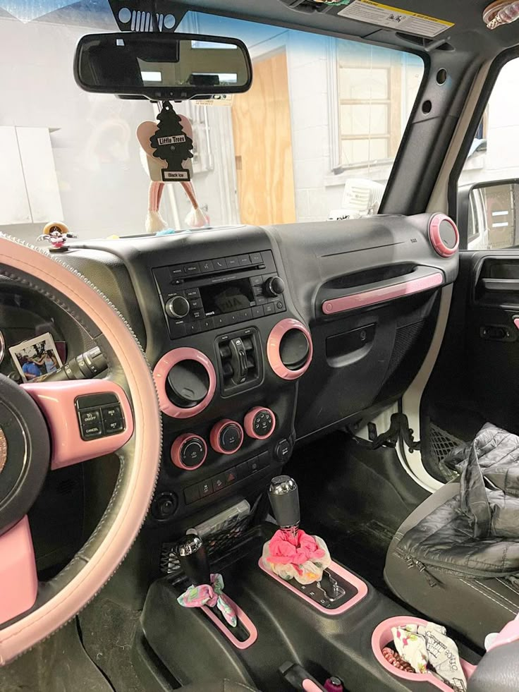 the interior of a pink and black car