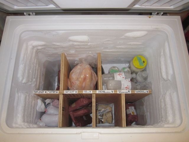 an open refrigerator filled with lots of food and plastic wrap around the bottom shelfs