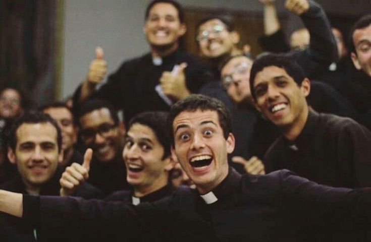 a group of men standing next to each other with their arms in the air and thumbs up