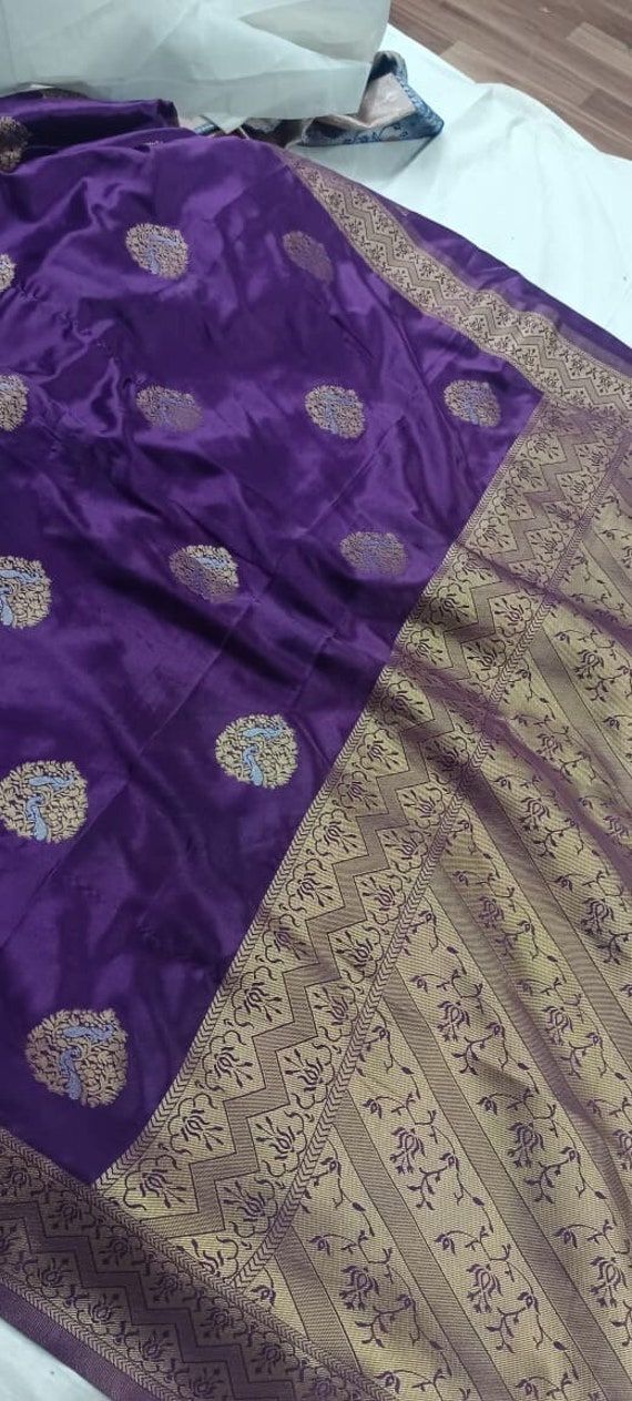 A beautiful aubergine Banarasi Silk saree - sarees that complete your ethnic look effortlessly. Banarasi sarees havr intensive weaving process, the use of premium Banarasi silk, intricate craftsmanship, and high demand for these exquisite sarees during special occasions. The rich shine and weaving makes them look royal.  This saree is perfect for all types of indian functions :- like- Pooja, Mehandi, wedding, etc Traditional Purple Dupatta For Ceremonies, Festive Purple Traditional Wear, Festive Traditional Purple Wear, Traditional Purple Pre-draped Saree For Navratri, Traditional Purple Dupatta For Festive Occasions, Traditional Purple Banarasi Silk Blouse Piece, Purple Katan Silk Dupatta In Bollywood Style, Purple Unstitched Saree For Traditional Ceremonies, Unstitched Purple Saree For Traditional Ceremonies