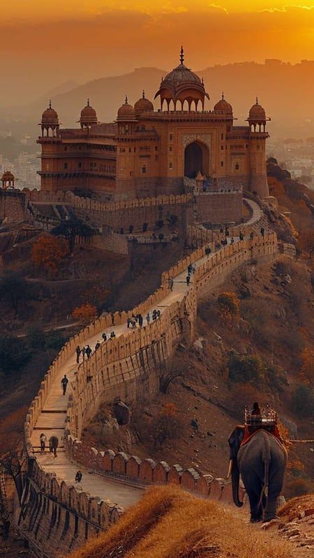 an elephant is walking down the road towards a castle on top of a hill at sunset