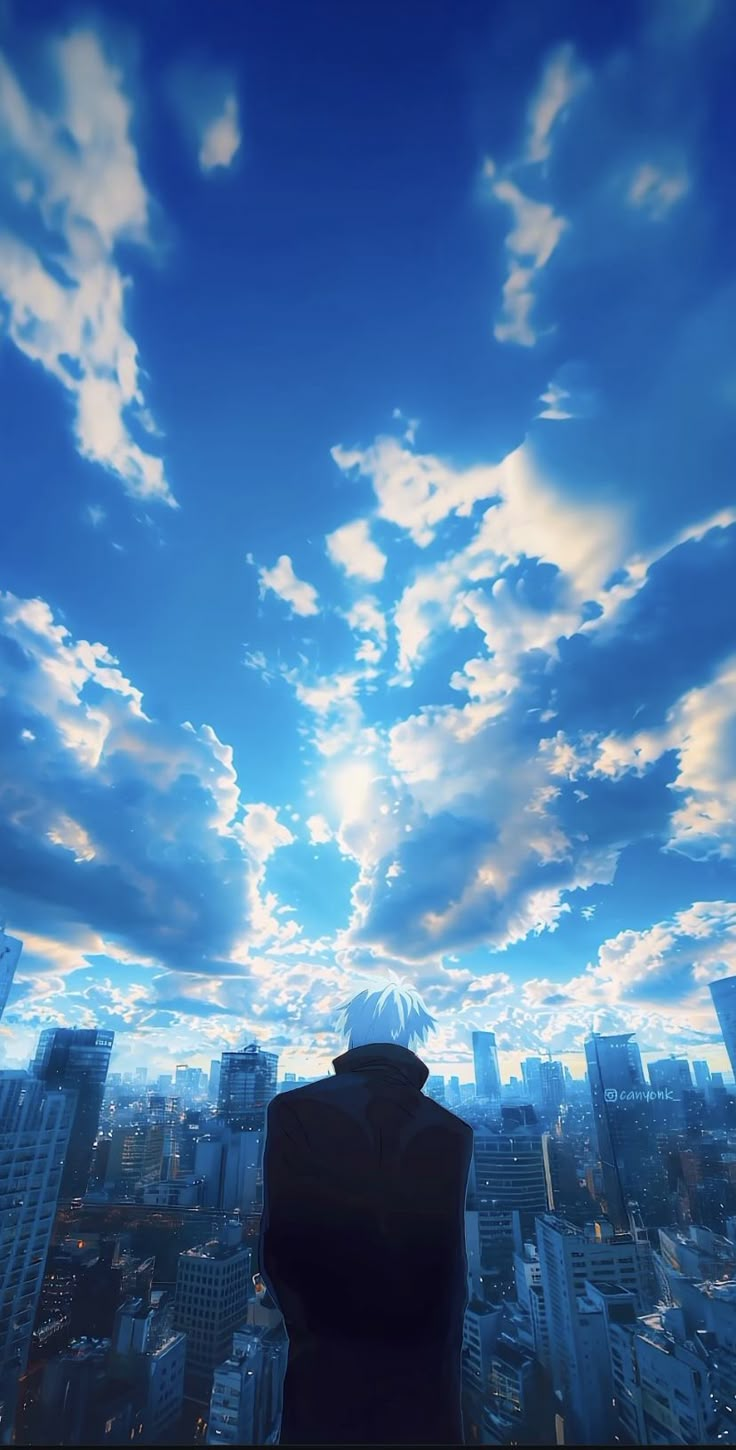 a man standing on top of a tall building under a blue sky filled with clouds