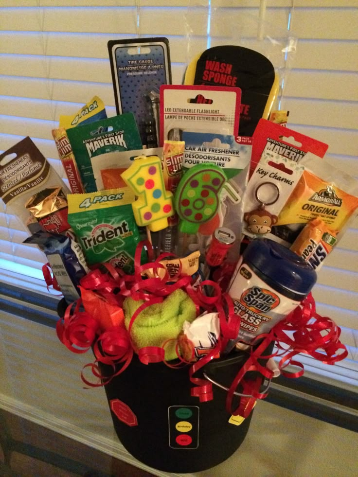 a black bucket filled with lots of different types of snacks and candys on top of a window sill