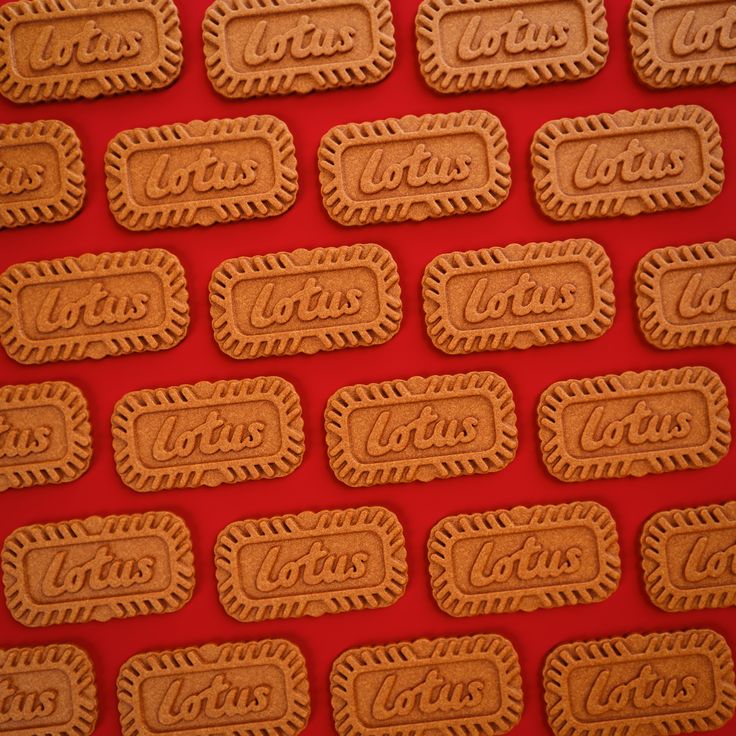 some cookies are arranged in the shape of coca colas on a red tablecloth