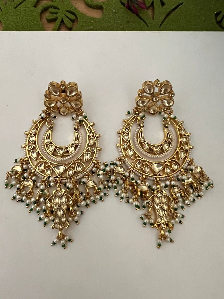 This intricately handmade pair with pearl drops is perfect for any traditional look.  You will definitely fall in love with these sabyasachi kundan earrings. Light weight and comfortable. One of our favourite picks for the wedding season . Be bold, be stylish, and be your best always. The weight of the earrings is 44 g. The length of the earrings is 9 cm. The width of earrings is 5 cm. Luxury Chandbalis With Stone Work For Reception, Reception Chandbali Chandelier Earrings In Kundan, Kundan Temple Jewelry Danglers For Reception, Luxury Kundan Bridal Earrings For Diwali, Kundan Danglers For Receptions And Festivals, Kundan Danglers For Reception And Festivals, Kundan Meenakari Chandbalis For Reception, Kundan Danglers For Reception And Diwali, Bollywood Kundan Danglers For Reception