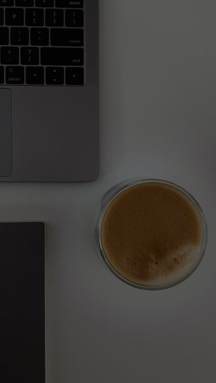 a cup of coffee next to a laptop computer