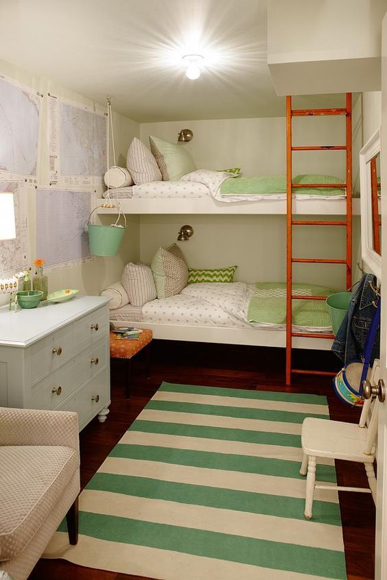 bunk beds in a small room with green and white striped rugs on the floor