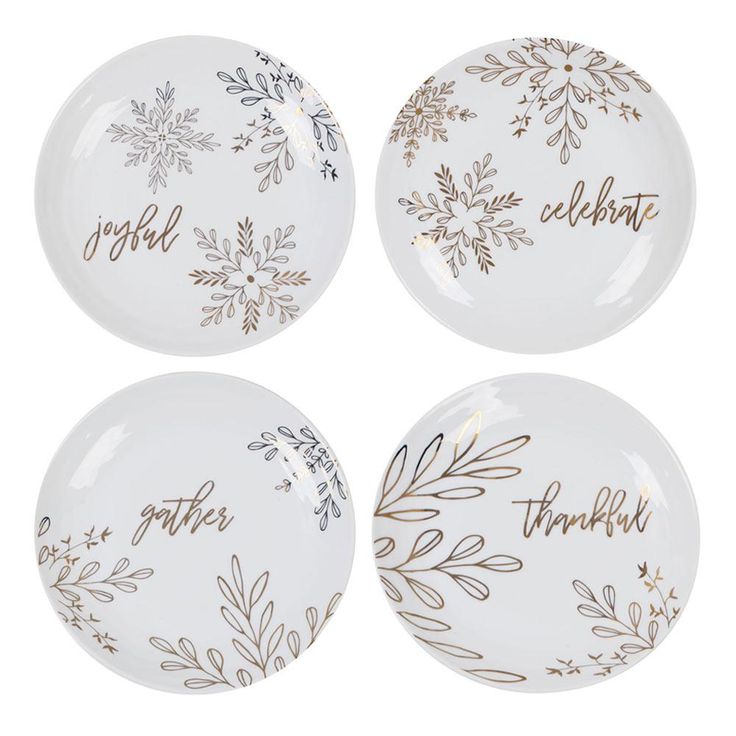 three white plates with gold lettering and snowflakes