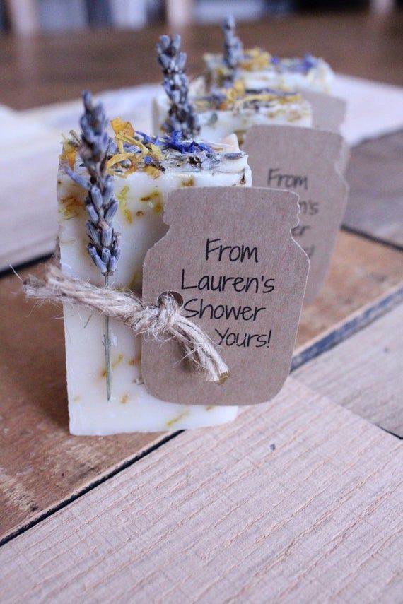 three soap bars sitting on top of a wooden table next to tags with words from lauren's shower tours