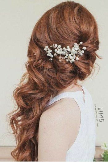 a woman with long red hair wearing a white dress and a flower in her hair