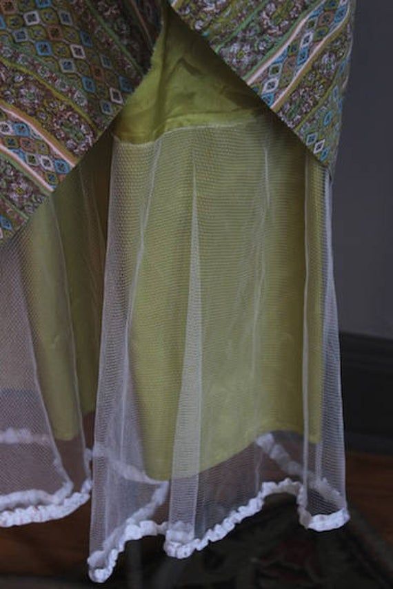 "50s inspired super cute midi dress in lovely shades of moss green, light blue and peach. Nice attached netted crinoline for a full circle skirt with lacey white trim exposed at the hem. Fully lined in chartreuse satin. Excellent condition. Side zipper and front buttons covered in matching fabric. Fits the following measurements: Bust up to 36\" Waist 28\" Hips free Length from nape of neck to hem is 38\"" Chartreuse Midi Dress, Chartreuse Dress Ocean+main, Chartreuse Earrings, Earth Shoes, Nape Of Neck, Full Circle Skirts, Leather Buckle, White Trim, Novelty Print