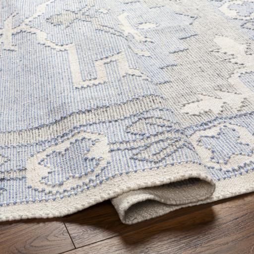 a blue and white rug is laying on the floor with it's corner open