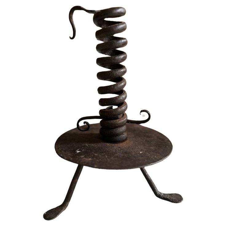 a metal object with spirals on top of it's legs and one foot in the air