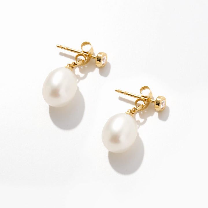 Inspirant un sentiment d'élégance intemporelle, ces boucles d'oreilles pendantes en perles en or massif 14 carats sont l'accessoire parfait pour toute occasion spéciale. Conçues pour la mariée moderne, la demoiselle d'honneur ou toute femme à la recherche d'une touche de luxe, ces boucles d'oreilles serties de zircones cubiques offrent une démonstration éblouissante de savoir-faire. Offrant un équilibre étonnant entre classique et contemporain, ces boucles d'oreilles de mariée 14 carats constitu Gold Pearl Drop Earrings, Pearl Wedding Earrings, Pearl Drop Earrings Gold, Bezel Set Earrings, Pearl Earrings Wedding, Set Earrings, Pearl Earring, The Modern Bride, Pearl Wedding