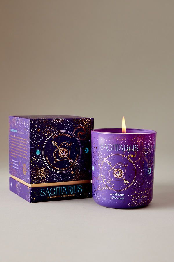 a purple candle sitting next to a box with an astro sign on it and the words sagitaurus written in gold