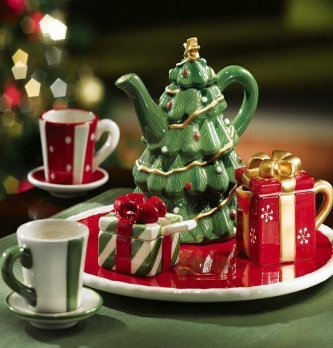 there is a tea set with a christmas tree on the plate and two mugs next to it