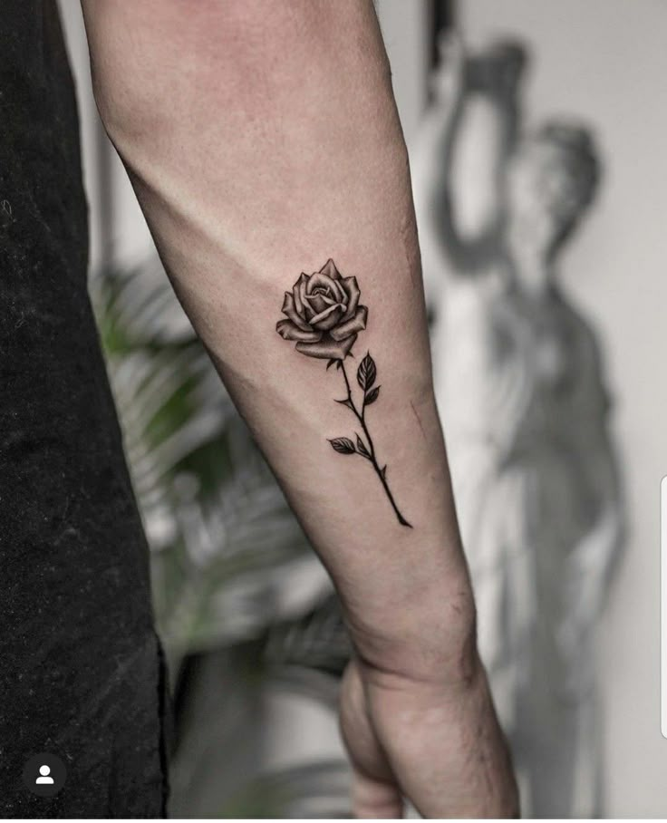 a black rose tattoo on the left arm