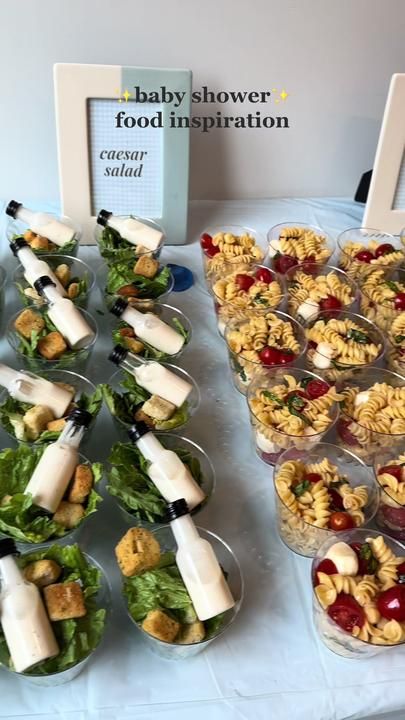 baby shower food is displayed on a table with cups and bowls filled with salads