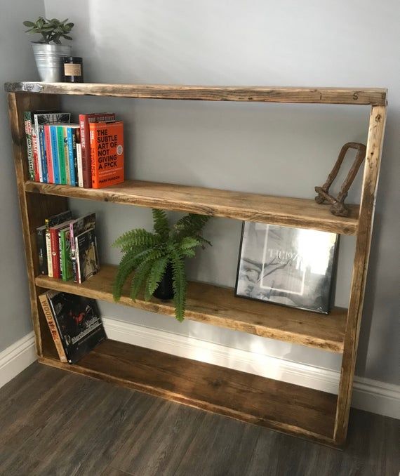 a wooden shelf with books and plants on it