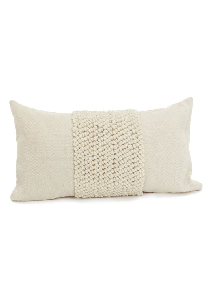 a white pillow with a braided design on the front and back, sitting against a white background