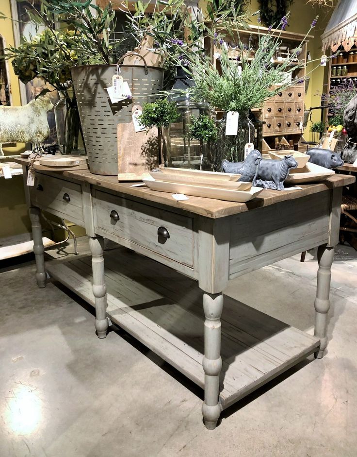 a table with plants on it in a room filled with other furniture and decor items