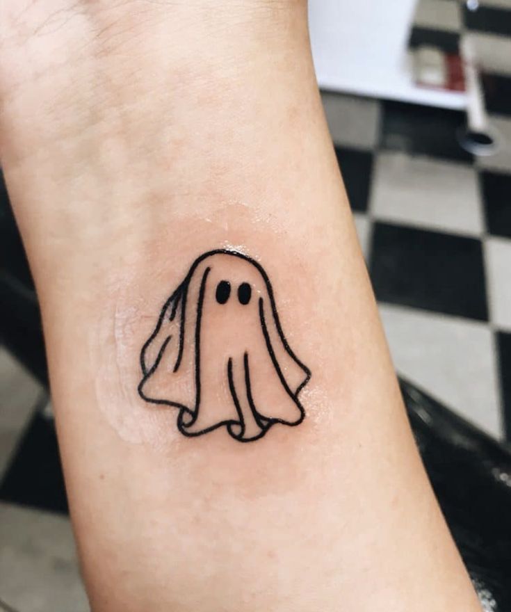 a small ghost tattoo on the wrist