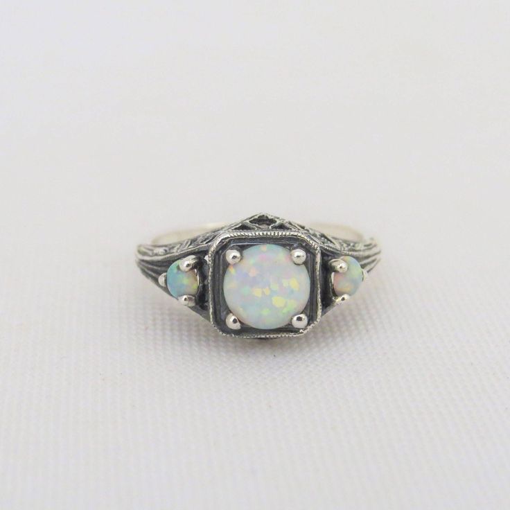 Vintage Sterling Silver White Opal Three stone Filigree Ring ....Marked 925....Total of weights 2.4grams...Size 9...Measure of Face 9MM...It's in very good condition. Adjustable Multi-stone Opal Ring For Anniversary, Antique Sterling Silver Ring With Gemstone, Silver Opal Ring With Stone Setting, Sterling Silver Opal Ring With Round Stone, Silver Opal Ring With Round Stone, Vintage Silver Multi-stone Opal Ring, Antique Sterling Silver Opal Ring For Anniversary, Antique Sterling Silver Rings With Stone Setting, Sterling Silver Opal Ring For Promise