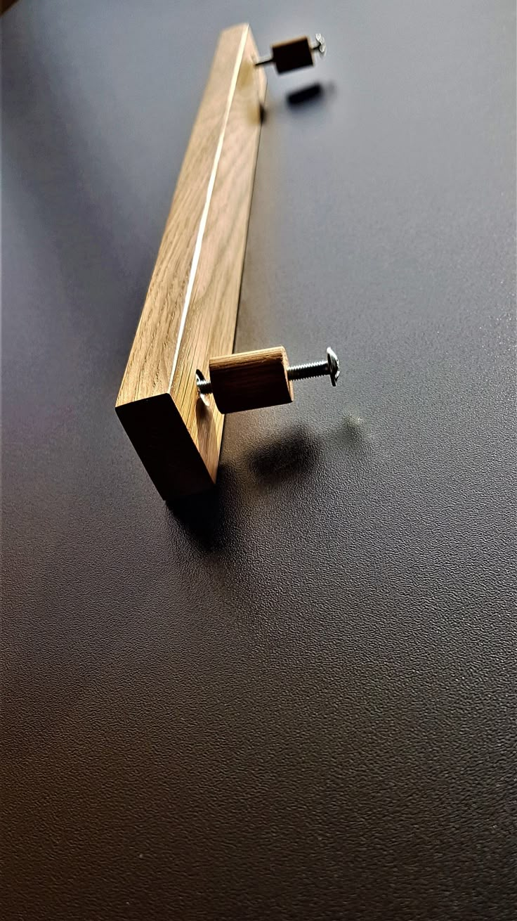 a close up of a piece of wood on a table with screwdrivers attached to it